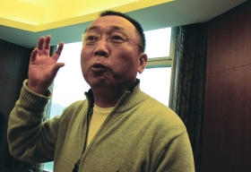 11月27日,重庆,李庄接受潇湘晨报记者采访,说到激动处用手不停比划。 图/记者倪志刚