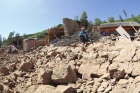 7月22日，甘肃省岷县禾驮乡，一位村民坐在地震废墟上。　　　　图/CFP