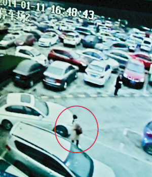 　　■女子（红圈处）站在停车位前，不准正常停车的唐先生进入车位。