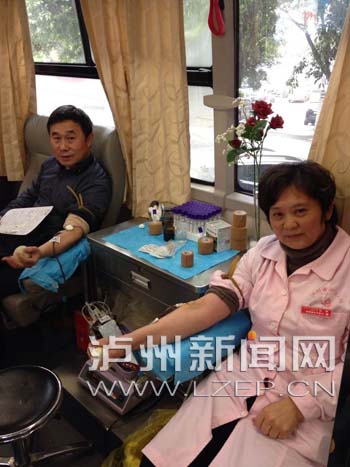 市中心血站的工作人员程文和丈夫一起献血