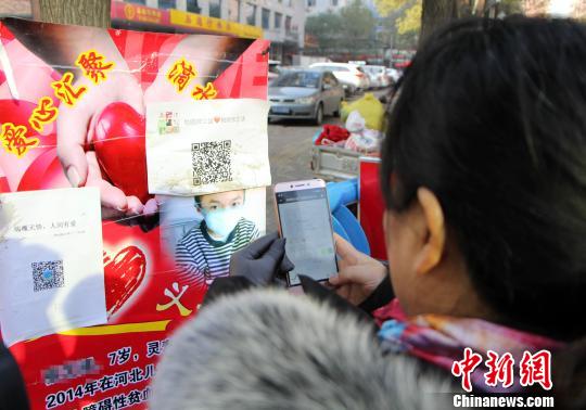 图为爱心人士扫微信二维码进群。　韩冰 摄