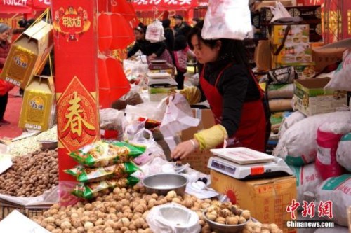 资料图:民众在超市采购新年喜庆饰品、酒水饮料和食品。张远 摄