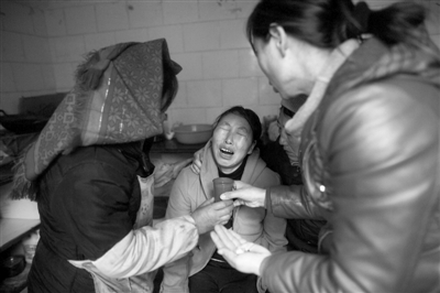 昨日，正在家中哭泣的罗远菊。此前，死者家属罗远菊从昆明赶回家中，这次事故让她失去了29位亲人。新京报记者周岗峰摄